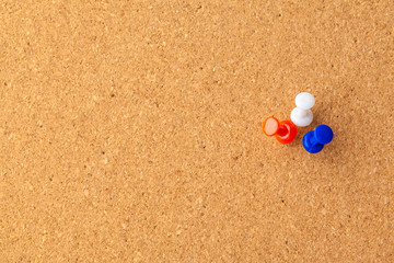 Group of thumbtacks pinned on corkboard