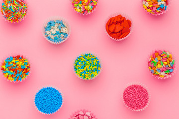 Sugar sprinkles, decoration for cake and ice-cream and cookies on pink background