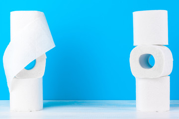 Toilet paper rolls stacked against blue background