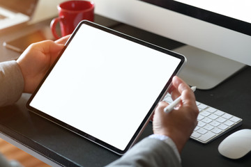 Businessman using tablet computer at office workspace.