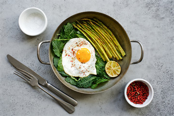 Fried egg with kale and asparagus. Healthy and nutritious food concept