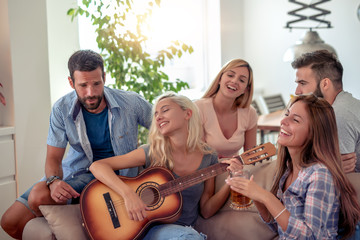 Group of friends have fun with guitar
