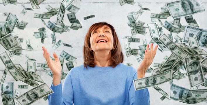 finances, wealth and success concept - grateful senior woman looking up under money falling from above over grey background