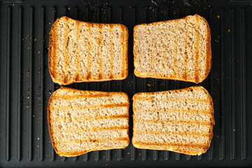Roasted toasted the bread until Golden brown. Electric grill roasting toaster bread. Grilled strips of grill on pieces of bread.