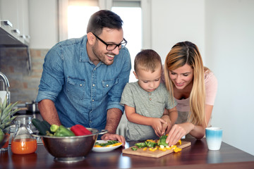 Lovely young family preparing meal in their kitchen