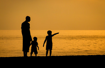 Fototapeta premium father and son on the beach at sunset