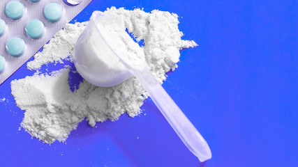 Sport supplement, creatine, hmb, bcaa, amino acid or vitamin mesure with powder. Sport nutrition concept. bcaa, l-carnitine, creatine in blue background