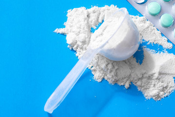 Sport supplement, creatine, hmb, bcaa, amino acid or vitamin mesure with powder. Sport nutrition concept in blue background