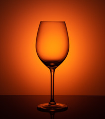 empty glass goblet on orange background