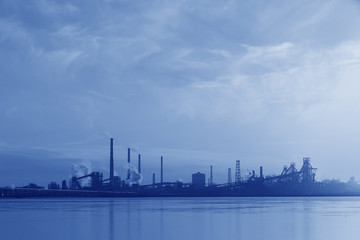 Fototapeta na wymiar A silhouette of a chemical plant in the setting sun