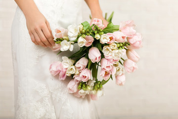 Obraz na płótnie Canvas Wedding bouquet of pink tulips in bride's hands