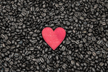 Red wooden heart on the roasted coffee beans