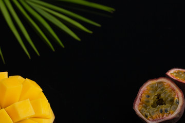 peeled pineapple, bamboo and passion fruit. Fresh Tropical Fruits. On a black background. Top view. Copy space.