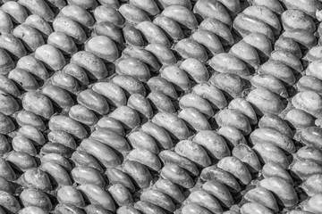 Carefully vertically poured pebbles as decorative floor covering, abstract background, Black and white, bw