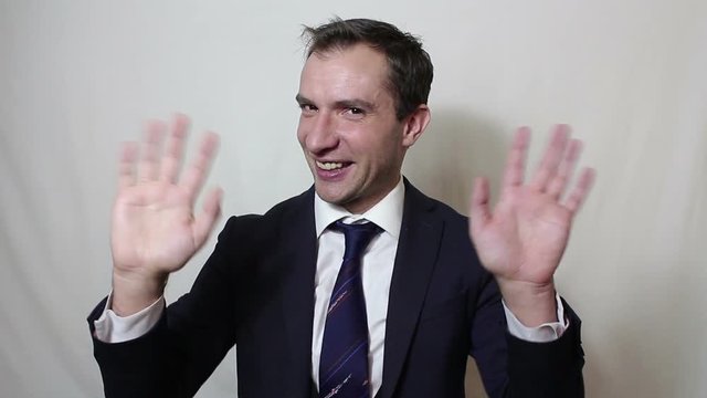 Young beautiful businessman in blue suit smiling and waving her hand greeting customers.Portrait on a white background.