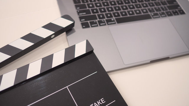 Black Movie slate or clapperboard and laptop use in video production ,film, cinema industry on white background.