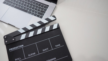 Fototapeta na wymiar Black Movie slate or clapperboard and laptop use in video production ,film, cinema industry on white background.