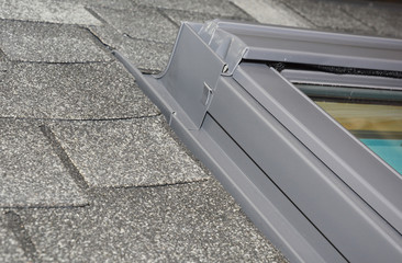 Skylight window waterproofing installation details on house asphalt shingles rooftop. Roofing...