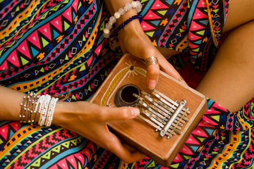 Woman holding kalimba in her hands and playing