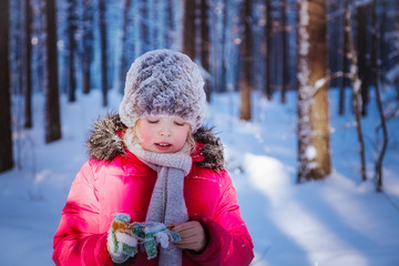 Fototapeta na wymiar Girl is walking on a winter day in the forest