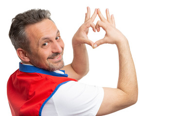 Supermarket employee showing heart gesture.