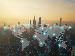 Digital network connection lines of Kuala Lumpur Downtown, Malaysia with world map. Financial district and business centers in smart city in technology concept. Skyscraper and high-rise buildings