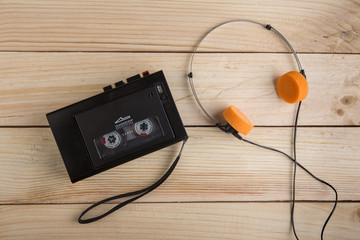 Old portable cassette player on a wooden background