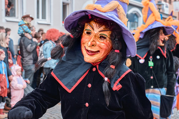 Witch with big hat runs enthusiastically. Street Carnival in Southern Germany - Black Forest.