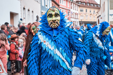 Carnival figure with blue costume and green mask. Street Carnival in Southern Germany - Black Forest.