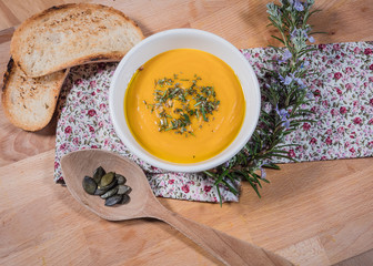 smooth creamy pumpkin soup in a bowl on wood background.  top view. healthy vegetable mashed with herbs and seeds on surface 4