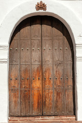 Fototapeta na wymiar Old wooden front door of Spanish mission Basilica San Diego de Alcala, California, USA