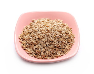 Spelt grains, heap in bowl isolated on white background, macro