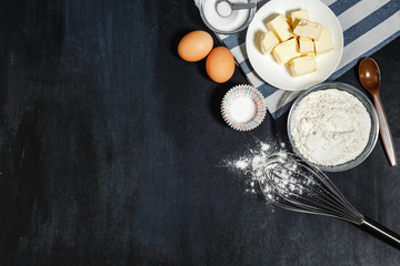 Ingredients for baking-flour, spoon, whisk, butter, eggs. Top view, copy space