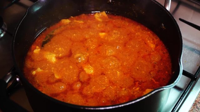 Meat in tomato sauce in a pan of boiling. With onions, tomatoes, paprika, chili pepper, cumin, dill. Hungarian cuisine is goulash.