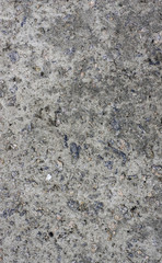 The texture of the old concrete wall with stones, cracks, dust, cracks, roughness. Texture, background