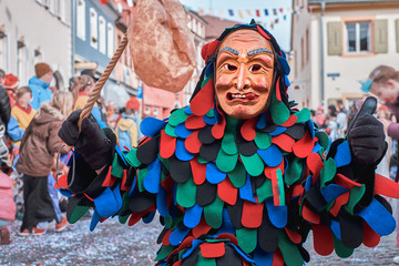 Colorful carnival figure with tongue outstretched. Street Carnival in Southern Germany - Black...