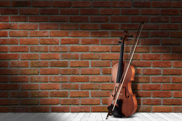 Vintage antique violin near brick wall background.