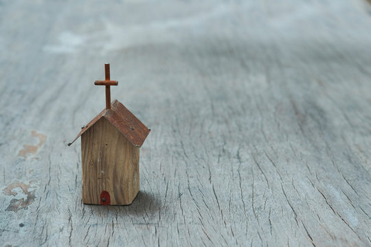 Small wooden church model on wooden background, still life photography with selective focus narrow depth of field on the church