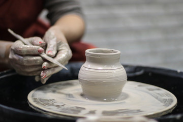 Fototapeta premium Hands of a Potter creating the clay. Vessel on the Potter's wheel.