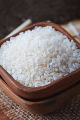 Raw uncooked sushi rice in wooden bowl. Concept for preparing sushi