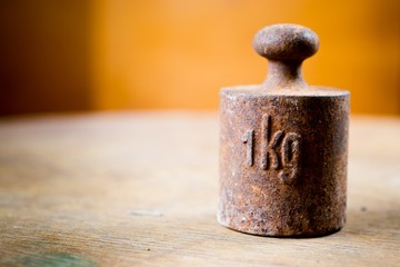 1 kg rusty weight in shallow focus. Old rusty measurement steel piece.