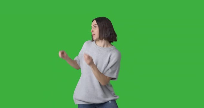 Happy woman dancing over green background