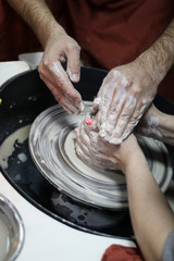 Hands of a Potter creating the clay on the Potter's wheel.