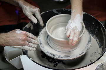 Hands of a Potter creating the clay.  Vessel on the Potter's wheel.
