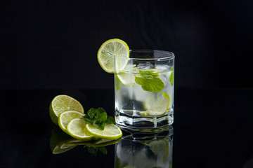 Summer cocktail mojito in glass on black background..