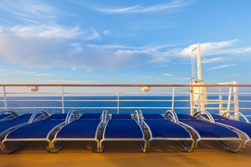 Pool benches along the fence with background of the calm blue sea