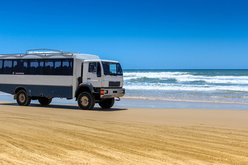 offload bus trip on beach road higway in fraser island, travel australia adventure