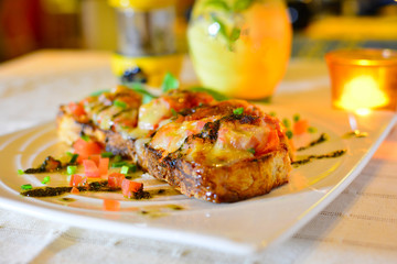 Bruschetta topped with Tomato, Mozzarella Cheese, with fresh basil leaves for a traditional Italian appetizer or snack