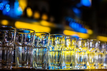Empty glasses in the pub with color light from background