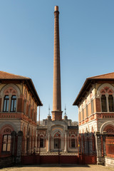 Fototapeta na wymiar Antigua chimenea de una fábrica en el norte de Italia